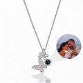 Custom butterfly-shaped photo projection necklace in silver, with a hidden projection bead displaying a photo of a couple
